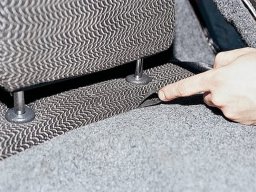 Снять спинку заднего сиденья, потянув вверх лямку фиксатора