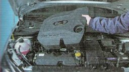 Снять пластиковую накладку двигателя, потянув вверх.