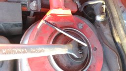 Открутить гайку крепления штока, удерживая шток стойки